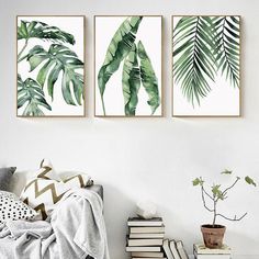 three green leaves are hanging on the wall above a bed in a bedroom with white walls