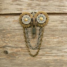 a close up of a clock with chains on it's face and flowers in the middle