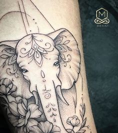 an elephant with flowers on it's leg is shown in black and grey ink