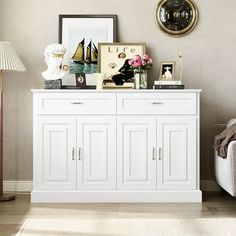 a living room with a white cabinet and pictures on the wall