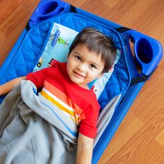 a young boy laying on top of a blue mat