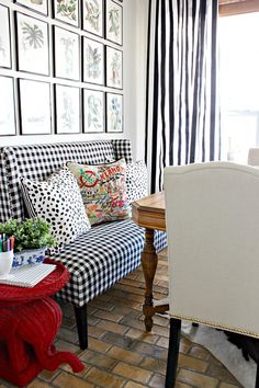 a black and white checkered couch sitting in front of a window next to a wooden table