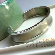 Men's wide steel cuff bracelet made from stainless steel.  Size M.Metal: high quality stainless steelLong Diameter: 2 1/2  Short Diameter:  2"Circumference:  7 3/4"Width:  a little big wider than 1/2", 14mmThickness: 2.5mmMeasurements are an approximation Engraving service is not available for this bracelet.Good quality of stainless steel jewelryhttp://360jewels.blogspot.com/2009/12/why-stainless-steel-jewelry-works.htmlThanks for your interest in our men's cuff bangle made from stainless steel. Bracelet For Men Silver, Unique Bangle, Stainless Steel Bracelet Men, Mens Cuff, Bangles Making, Jewelry Words, Stainless Steel Bangles, Cuff Bangle Bracelet, Men's Bracelet