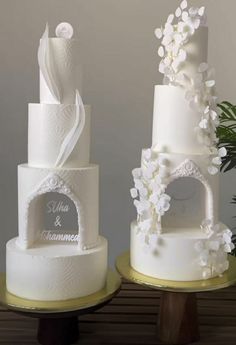 two white wedding cakes sitting on top of each other