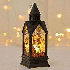 a small lantern with a tree and animals on it