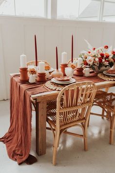 the table is set with candles and plates