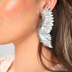 The Silver Statement Wing Earrings are the perfect accessory for those who want to make a bold statement with their jewelry. The wings symbolize freedom and lightness, and these earrings capture that essence in their unique design. The handmade sequins shimmer in the light, catching the eye and adding a touch of glamour to any outfit. These silver wing earrings are perfect for any occasion, from a night out with friends to a formal event. Add these stunning earrings to your collection and elevat Elegant Winged Jewelry For Parties, Metal Wrap Drop Earrings For Party, Elegant Metal Wing-shaped Earrings, Elegant Wing-shaped Metal Earrings, Trendy Pierced Wrap Earrings For Party, Metal Wrap Earrings For Party, Trendy Pierced Crystal Earrings For Party, Glamorous Pierced Crystal Earrings For Party, Glamorous Pierced Crystal Party Earrings