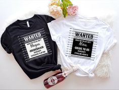 two t - shirts sitting next to each other on top of a white table with flowers