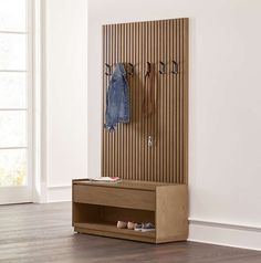 a coat rack with two coats hanging on it and some shoes in front of it