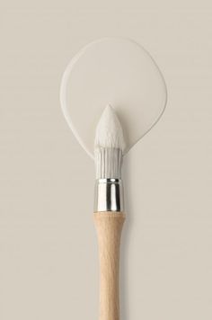 a white paint brush with a wooden handle