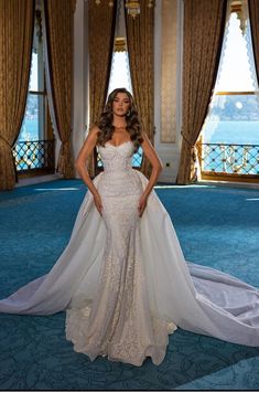 a woman in a white wedding dress posing for a photo on the blue carpeted floor