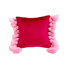 a pink pillow with pom - poms on the sides and a red cushion