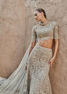 Luxuriously curated Long Gown with a double beaded neckline combined with intricate hand detailing of pearls, diamonites, sequence and a scalloped worked border cascading regally over tulle based lehnga. Color : Grey Fabric Details Gown: Hand Embellished Pure Organza Dupatta: Embroidered NET Blouse: Hand Embellished Pure Organza Replicate Designs  by Libaas Khaas Embroidery Hand Work, Grey Lehenga, Saira Shakira, Scalloped Blouse, Lehenga Dupatta, B Design, Organza Lehenga, Net Blouses, Embroidery Hand