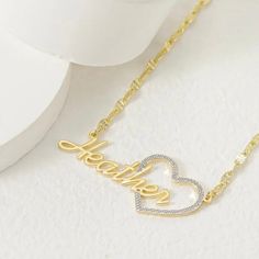 Show your love and appreciation with this stunning custom heart name pendant. This pendant features a two tone design of 10k vermeil gold and sterling silver, creating a beautiful contrast and a unique look. The pendant is shaped like a heart, with a cut-out of your chosen name in the center. The name is also plated with 10k vermeil gold, adding a touch of elegance and sparkle. The pendant comes with a 10k gold 18 inch matching chain, making it ready to wear or gift. This pendant is a perfect wa Customized Gold Double Heart Necklace, Customized Gold Heart Necklace For Mother's Day, Customizable Gold Heart Necklace For Mother's Day, Gold Double Heart Name Necklace, Gold Heart Necklace With Name For Mom, Gold Heart Nameplate Necklace, Gold Nameplate Heart Necklace, Gold Double Heart Name Necklace As Personalized Gift, Gold Double Heart Name Necklace For Personalized Gift