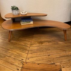 a wooden table sitting on top of a hard wood floor next to a white couch