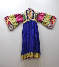 A beautiful Handmade Tribal Kutchi Dress from Afghanistan. Embellished with detailed beading and embroidery this dress has a rich floral silk skirt with gold lame, beading and embroidery. Kutchi embroidery has approximately 16 different types of stitches and styles and it is these variations that allow for the differentiation between the communities. Embroidery techniques are passed down from mother to daughter. The traditional dress of Afghanistan was very tremendous and elegant; especially the Traditional Brocade Dress With Floral Embroidery, Transitional Multicolor Embroidered Fitted Dress, Traditional Brocade Dress With Gold Embroidery, Traditional Embellished Silk Embroidered Dress, Traditional Embellished Embroidered Dress With Drape, Festive Traditional Embroidered Dress, Fitted Embellished Dress For Traditional Ceremonies, Festive Multicolor Embroidered Embellished Dress, Embellished Dresses For Festive Traditional Ceremonies