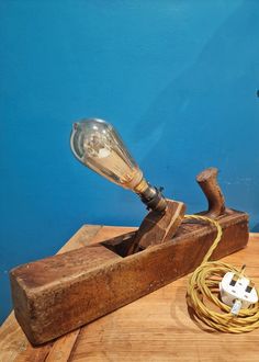 a light bulb sitting on top of a wooden block next to a power cord and plugged in