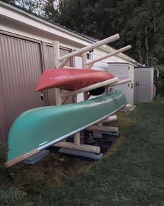 two canoes sitting on top of each other in front of a building with metal siding