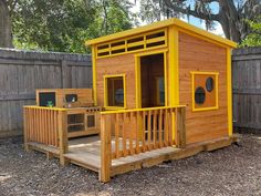 a small wooden shed with yellow trim and doors on the outside, in front of a fence