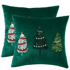 two christmas trees on green velvet pillows with white and red trimmings are shown