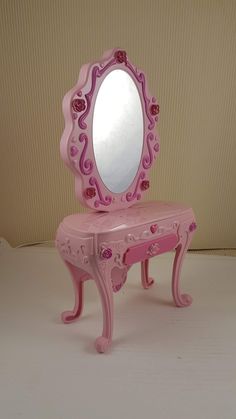 a pink dressing table with a mirror on it's top and hearts painted on the side