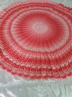 a crocheted doily is laying on a white sheet