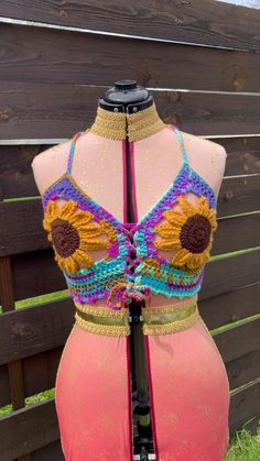 Unleash your free spirit with our Sunflower Corset Top! 🌻 Perfect for sizes medium to large, D cup, this crochet masterpiece is a festival of boho-chic and cottagecore dreams. Embrace your inner witchy fairy with a unique, ready-to-ship top that's as authentic as you are. Ideal for festivals, or simply celebrating everyday magic. 🌿✨ #BohoHippie #FairycoreFashion #CrochetTop

Funky and fresh, this colorful top is sure to catch some looks 🌻 This style of top has lacing in both the front and back for ultimate adjustability. Pictured on a 35 inch bust. Refer to made to order listing for custom sizing and colors.

MEASUREMENTS 

M/L

D cup: 9 inches top to bottom at tallest point and 9.5 inches across from center of chest to armpit area

Flower center/nipple coverage: 4 inch diameter and 7 i Bohemian Vacation Patterns, Yellow Bohemian Crochet Top For Festival, Bohemian Multicolor Summer Patterns, Summer Fitted Crochet Lace Patterns, Fitted Crochet Patterns For Beach, Bohemian Crochet Patterns For Vacation, Fitted Bohemian Patterns For Summer, Bohemian Summer Vacation Patterns, Pink Crochet Lace Top For Festival