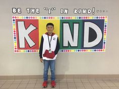 a young boy standing in front of a sign that says be the i'm kid