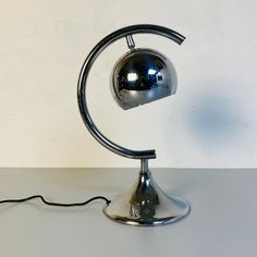 a chrome colored lamp with a black cord