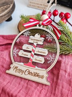 a christmas ornament hanging from a tree on top of a red cloth covered table