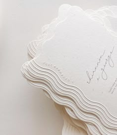 the wedding stationery is laid out on top of each other