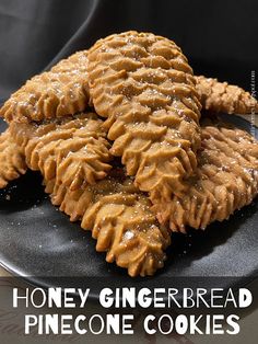 honey gingerbread pine cone cookies on a black plate with text overlay that reads, honey ginger bread pine cone cookies