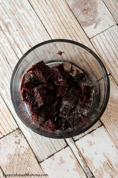 a glass bowl filled with brownies on top of a wooden table