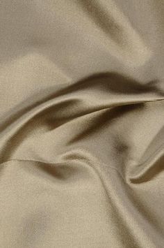 a close up view of a plain tan fabric with very soft folds and wrinkles