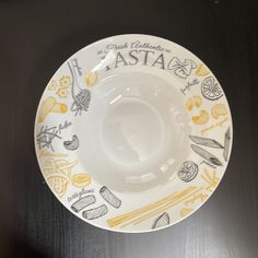 a white and yellow china plate with the words asia on it, sitting on a black table