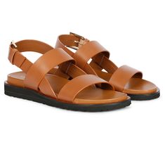 Step into summer with these leather sandals, a perfect fusion of craftsmanship and contemporary style. They feature chic front straps and an adjustable ankle strap, offering both a modern look and a comfortable fit. The padded leather footbed ensures all-day comfort, making them your ideal choice for any occasion, from casual strolls to professional gatherings. From Saint G. Spring Leather Strap Sandals, Summer Double Strap Sandals With Leather Sole, Leather Sandals With Adjustable Strap, Spring Leather Sport Sandals With Strap, Leather Open Toe Sandals With Strap, Leather Ankle Strap Sport Sandals For Vacation, Modern Leather Sport Sandals For Vacation, Modern Ankle Strap Sandals With Leather Footbed, Leather Strap Sandals For Summer