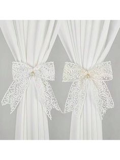 two white curtains with bows on them