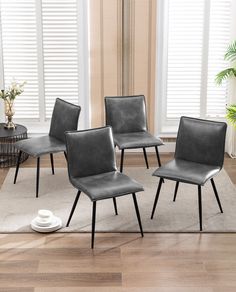 four brown leather chairs sitting on top of a rug