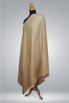 The "Tauqeer-e-Tan" shawl stands as an epitome of grace and poise, with its understated champagne tones and Sozni embroidery that speaks the language of quiet luxury. Crafted from the softest merino wool, the shawl is adorned with delicate patterns that are the hallmark of Kashmiri artistry. Each motif is hand-embroidered with utmost care and precision, demanding months of dedication to achieve the subtlety and detail that this piece exudes. It is a true reflection of the time-consuming and intr Tan Shawl, Sozni Embroidery, Embroidered Rug, Embroidered Handbag, Silk Carpet, Embroidered Wool, Pashmina Shawl, Embroidered Bag, Pashmina Scarf