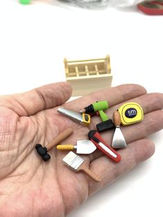 a person's hand is full of miniature tools