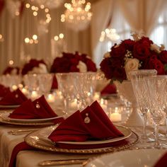 the table is set with red napkins and wine glasses, silverware, and roses