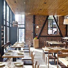 the interior of a restaurant with tables and chairs set up in rows, along with large windows