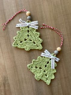 two crocheted christmas ornaments on a wooden table