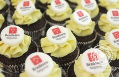 cupcakes with white frosting and red logos on them