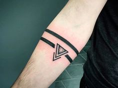 a man's arm with a black and white triangle tattoo on the left forearm