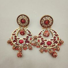 Enhance your look with these elegant Coral Chandbali Earrings. Featuring intricate designs with coral drops, these earrings bring a perfect blend of tradition and sophistication to any outfit. Ideal for festive occasions, they add a vibrant and graceful touch to your ensemble. Length: 3" to 3.5" Material: 24Kt gold foil, lac Stones: Kundans, semi precious corals, semi precious pearls Party Temple Jewelry Earrings With Dangling Beads, Traditional Red Pearl Earrings For Party, Bollywood Chandbalis With Dangling Beads For Diwali, Bollywood Style Chandbalis With Dangling Beads For Diwali, Festive Kundan Earrings With Dangling Beads, Kundan Earrings With Dangling Beads For Festive Occasions, Traditional Pearl Earrings With Dangling Beads For Party, Festive Meenakari Beaded Earrings For Celebration, Bollywood Chandbalis With Dangling Beads For Festive Occasions