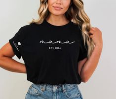 This Mama shirt with kids' names is perfect for any mama who wears her heart on her sleeve.Makes a great Mother's Day Gift for a new mom or new Grandma!Customize with any saying, (Mom, Gigi, Nana Etc.) and est. year.Customize with kids' names on sleeve.Featured on a short sleeve Comfort Color tee. ✨ HOW TO ORDER ✨✧ Select Options from the Drop Downs✧ Record personalization requests✧ ADD TO CART 🎨 GRAPHIC DETAILS 🎨► Professionally and Permanently Printing Process► Vibrant and Accurate colors► No Vinyl Used► Soft Print Water-Based Inks - NOT PLASTICY OR THICK! 📋 CARE INSTRUCTIONS 📋Feel free to throw it in the washer and dryer and get on with your day, the shirt will be fine! But for the best care we recommend:✧ Wash Gentle Inside out with Gentle Detergent (we DO NOT recommend Dreft or an Long Sleeve T-shirt For Mother's Day, Personalized Casual Tops For Mother's Day, Casual Personalized Tops For Mother's Day, Personalized Black Casual Tops, Casual Personalized Black Tops, Casual Personalized Tops, Casual Customizable Tops For Mother's Day, Casual Black Personalized Tops, Personalized Short Sleeve Tops For Gifts