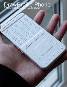 a hand holding a white cell phone in front of a window with the words drawbraile phone on it