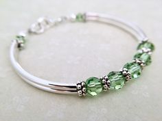 This birthstone bracelet can be personalized and gifted to your special someone. The recipient will most certainly feel special receiving this unique gift! All birthstone colors are available from the dropdown menu at checkout. OR, message me with a variety of colors to create a mother's bracelet. ~ peridot 6mm swarovski crystals ~ antiqued silver pewter spacers ~ silver plated tube bead bangles and lobster claw Click here to return to my shop's homepage: https://www.etsy.com/shop/beadedjewelryf Silver Bracelets With May Birthstone, Green Bracelet Jewelry For Birthday Gift, Green Bracelet For Birthday Gift, Adjustable Hypoallergenic Jewelry For Bridesmaid Gift, Hypoallergenic Bangle For Anniversary, Hypoallergenic Adjustable Jewelry For Bridesmaid, Hypoallergenic Green Jewelry For Weddings, Silver Beaded Birthstone Bracelet As Gift, Stackable Jewelry For May Birthstone Gift