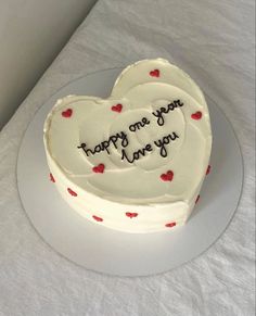 a heart shaped cake on a plate with the words happy one you have you written on it